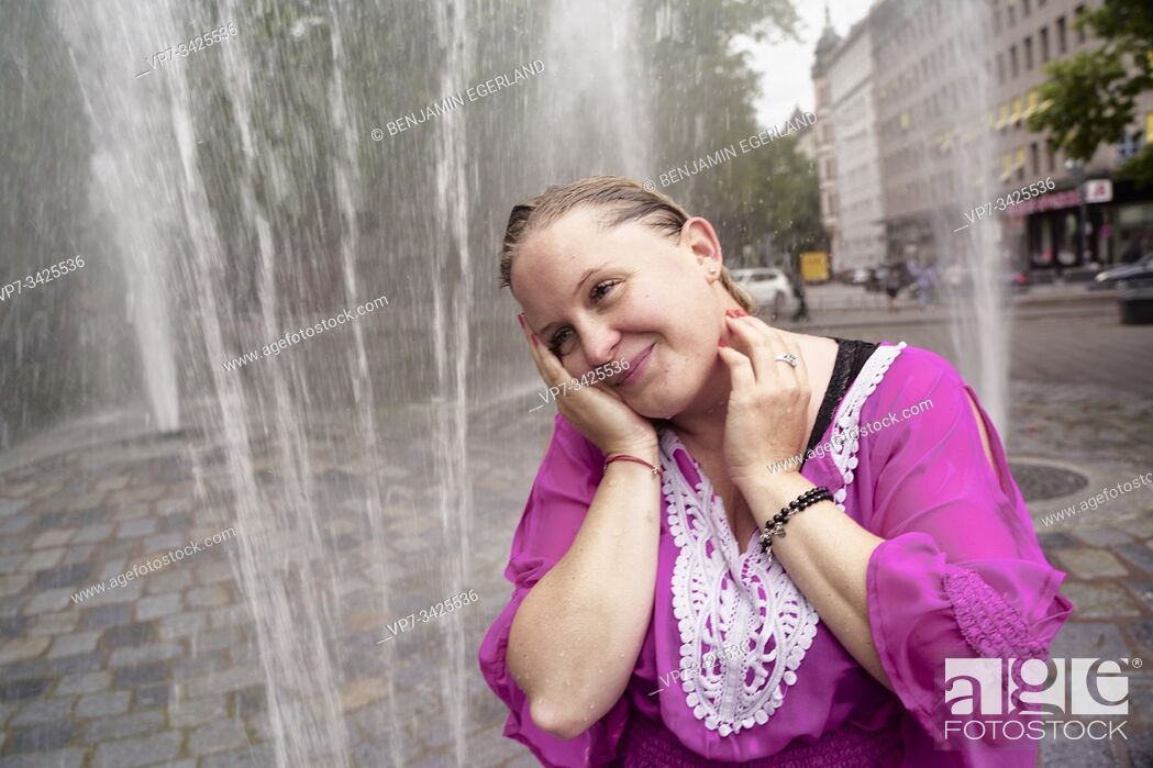 Photo de stock: Woman under fountain water spray, Munich, Germany.
