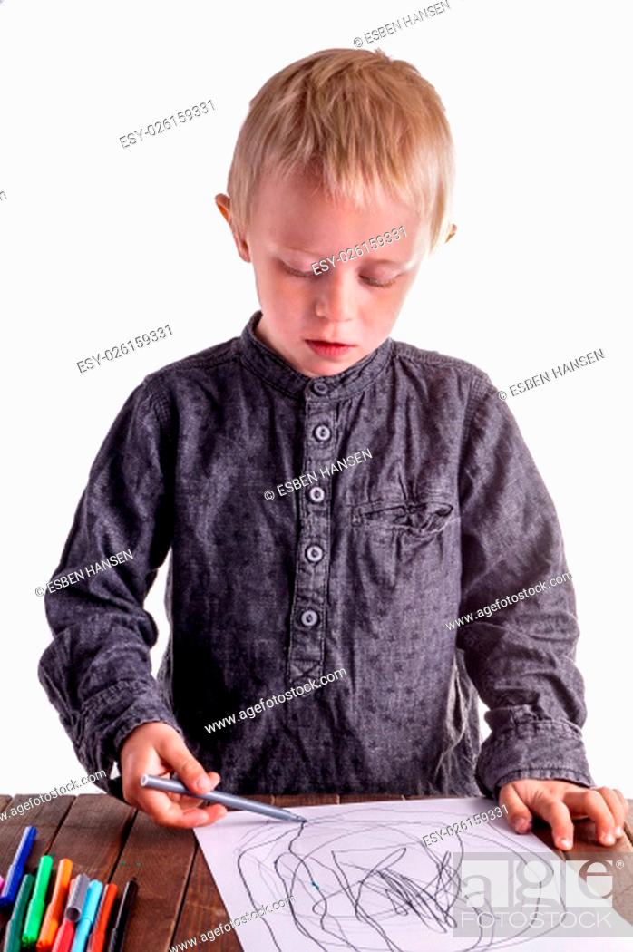 Stock Photo: Little boy draws a drawing. He has many markers and are very focused on what he is doing.