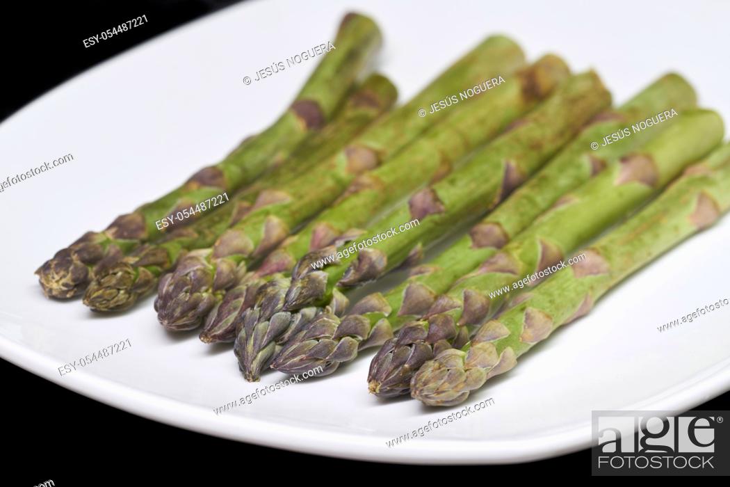 Stock Photo: green asparagus cut on black background.