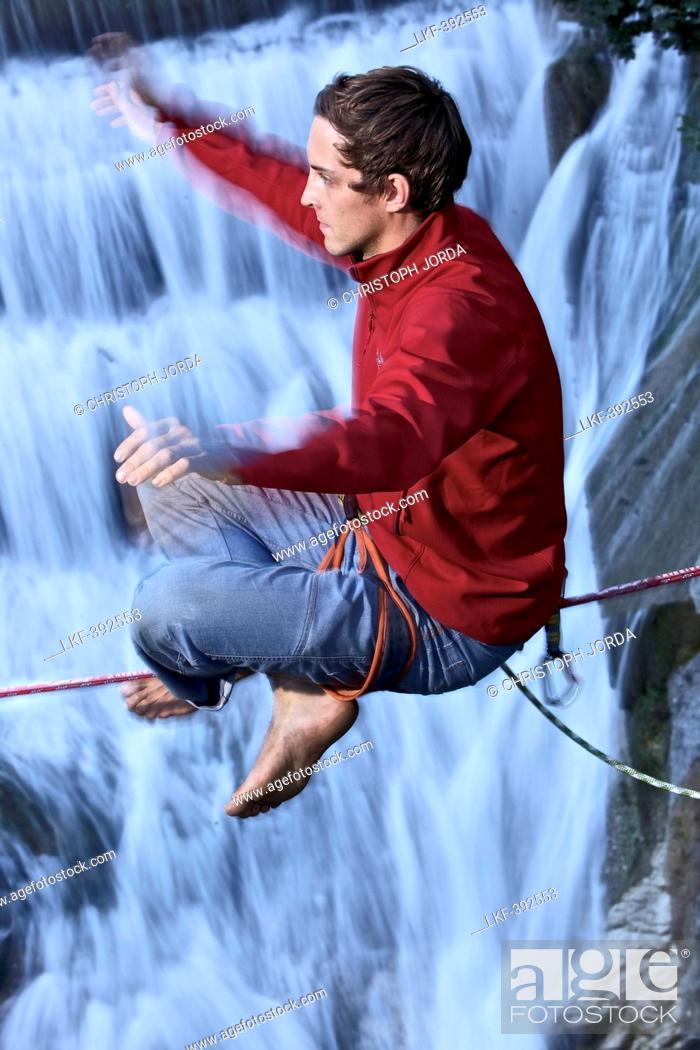 Stock Photo: Young man balancing on a highline over a stream, Fuessen, Bavaria, Germany, Europe.
