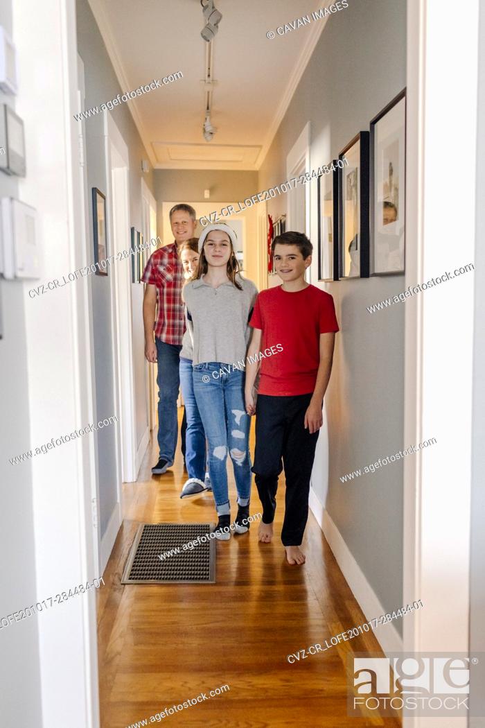 Stock Photo: Family of four standing by hallway of their home.