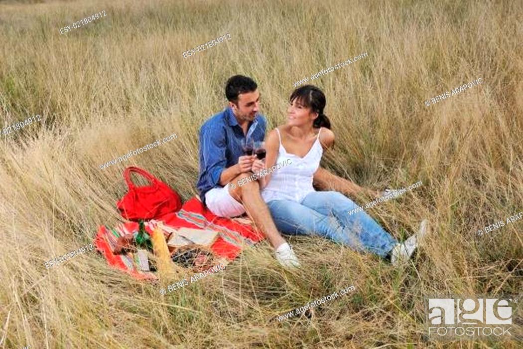 Stock Photo: happy couple enjoying countryside picnic in long grass.