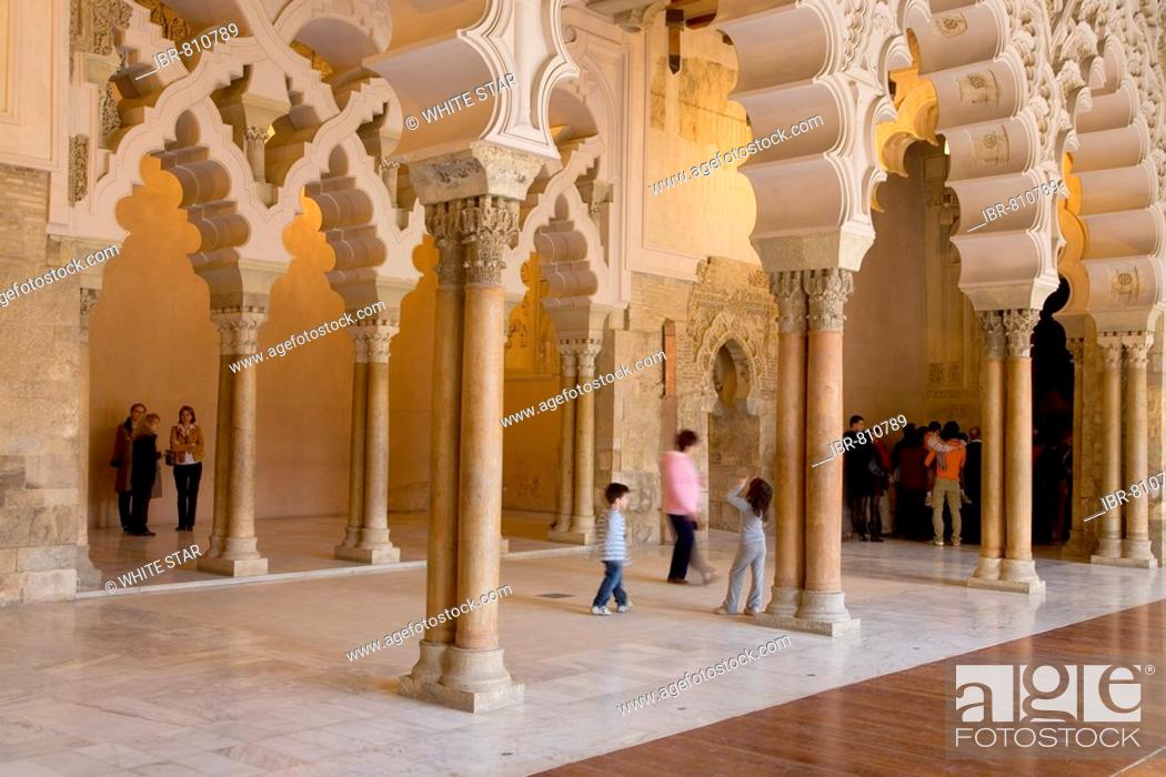 Stock Photo: Tourists beneath the ornate stone carved arched passageway of the Santa Isabel Patio, Palacio de Aljaferia palace, Moorish architecture, Zaragoza, Saragossa.