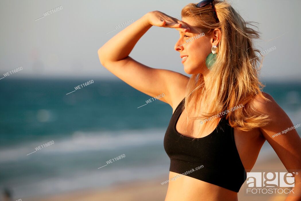 Stock Photo: Young woman of 25 on the beach looking out to sea.