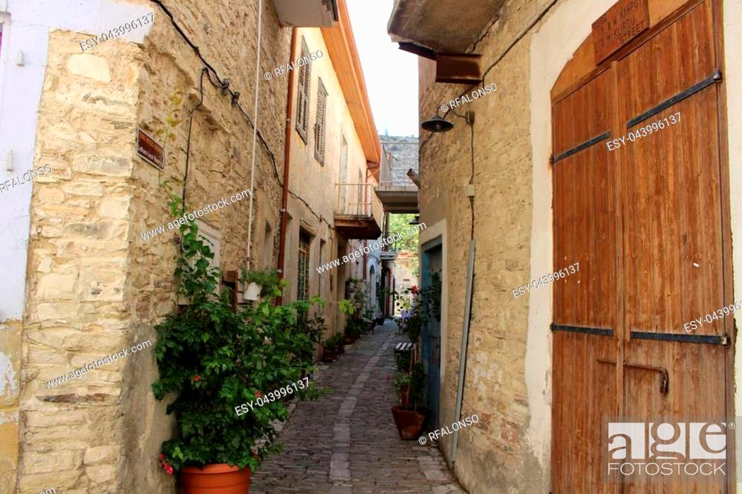 Stock Photo: Narrow street in Larnaca. Narrow walking road between traditional stone houses in Cyprus.