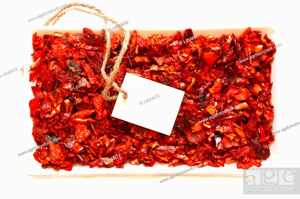 Stock Photo: Flakes of dry paprika in a bowl with empty tag on a white background.