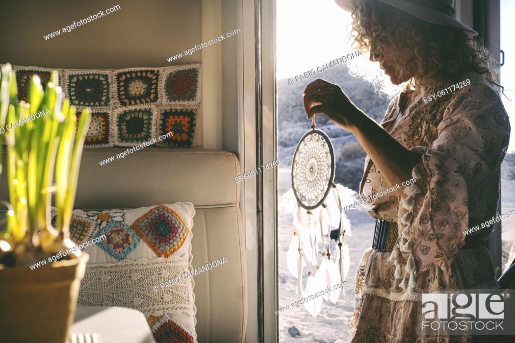 Stock Photo: Boho dress style trendy woman on the camper van door with a hand made dreamcatcher. Alternative female people enjoying travel wanderlust lifestyle and summer.