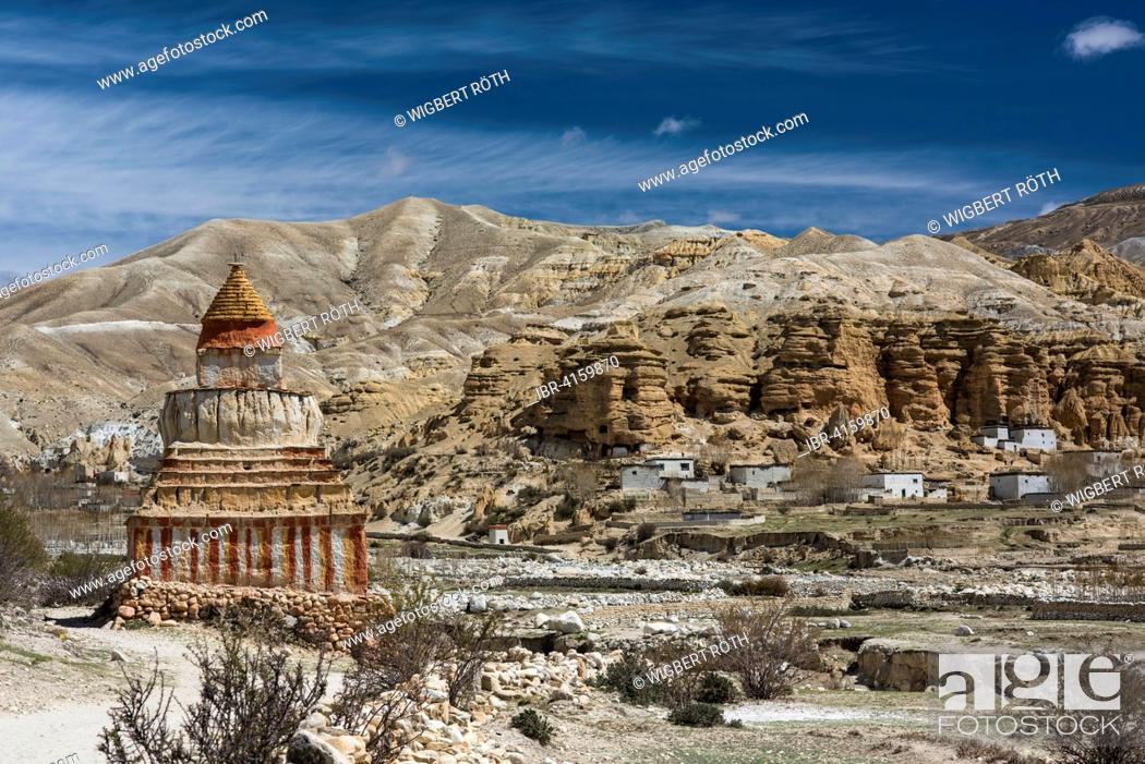 Stock Photo: Colourfully painted Buddhist stupa in front of mountain landscape, erosion landscape and houses of Garphu behind, Chhosar, Upper Mustang.