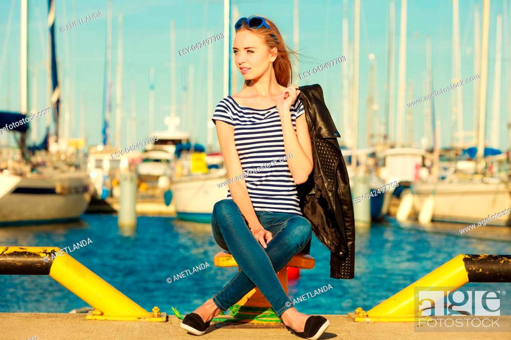 Stock Photo: Tourism relax and people concept. Fashion blonde girl with blue heart shaped sunglasses in marina against yachts in port.