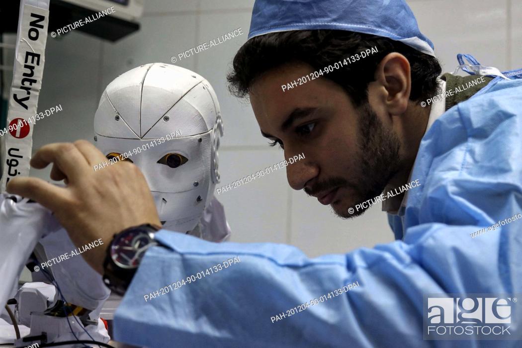 Stock Photo: 03 December 2020, Egypt, Tanta: A picture made available on 04 December 2020 shows mechatronics engineer Mahmoud El Koumy monitoring his Cira-03 robot while it.