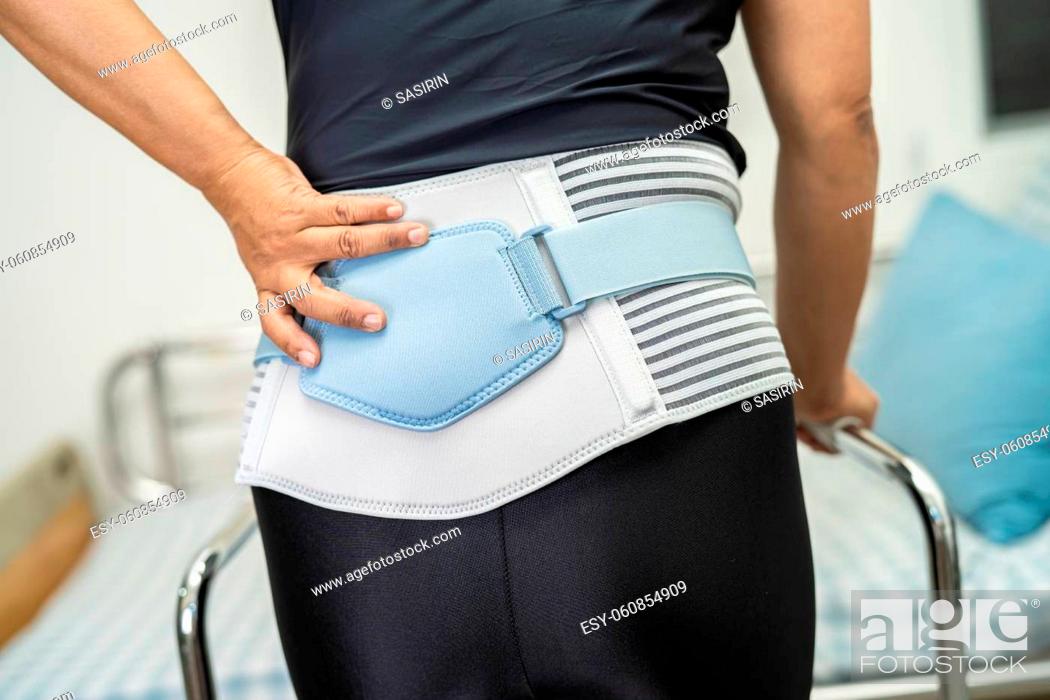 Stock Photo: Asian lady patient wearing back pain support belt for orthopedic lumbar with walker.