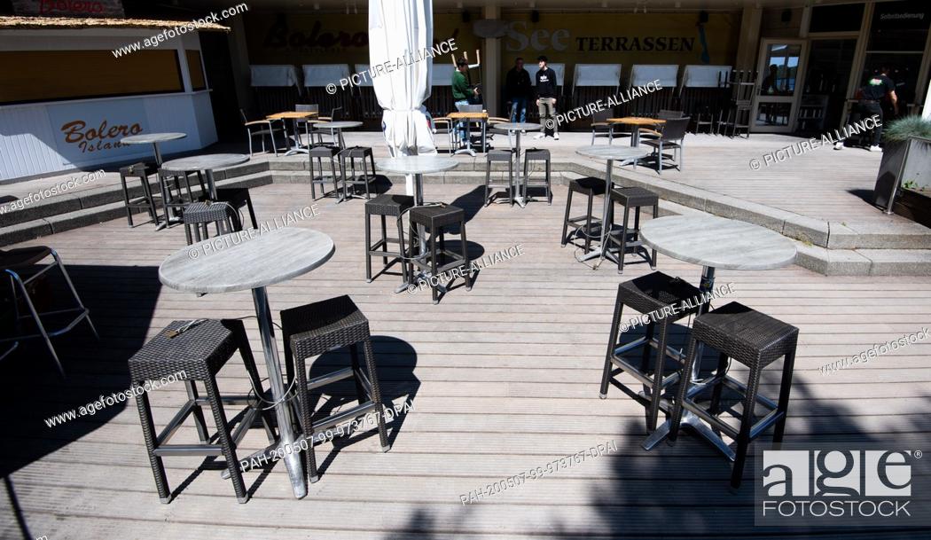 Stock Photo: 07 May 2020, Lower Saxony, Hanover: Bar tables and stools are located on the lake terraces at Maschsee, which are still closed due to the Corona pandemic.
