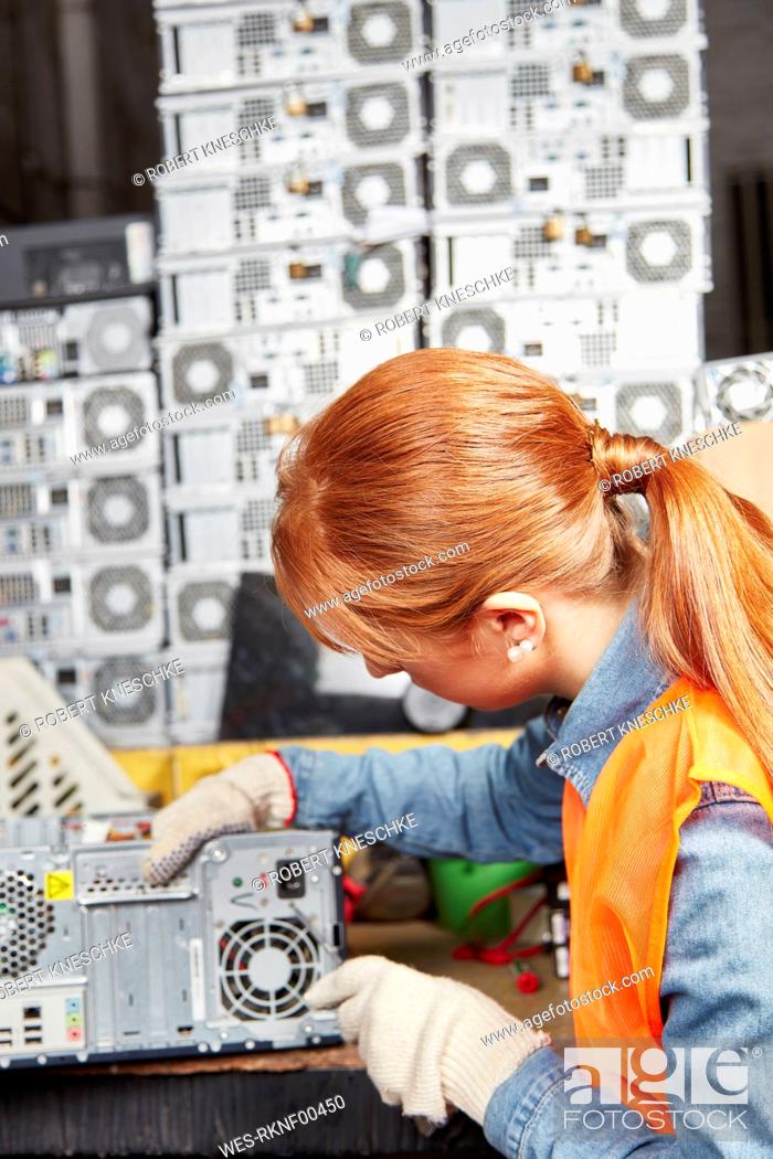Stock Photo: Female worker in computer recycling plant opening pc casing.