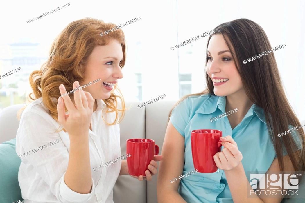 Imagen: Friends with coffee cups conversing at home.