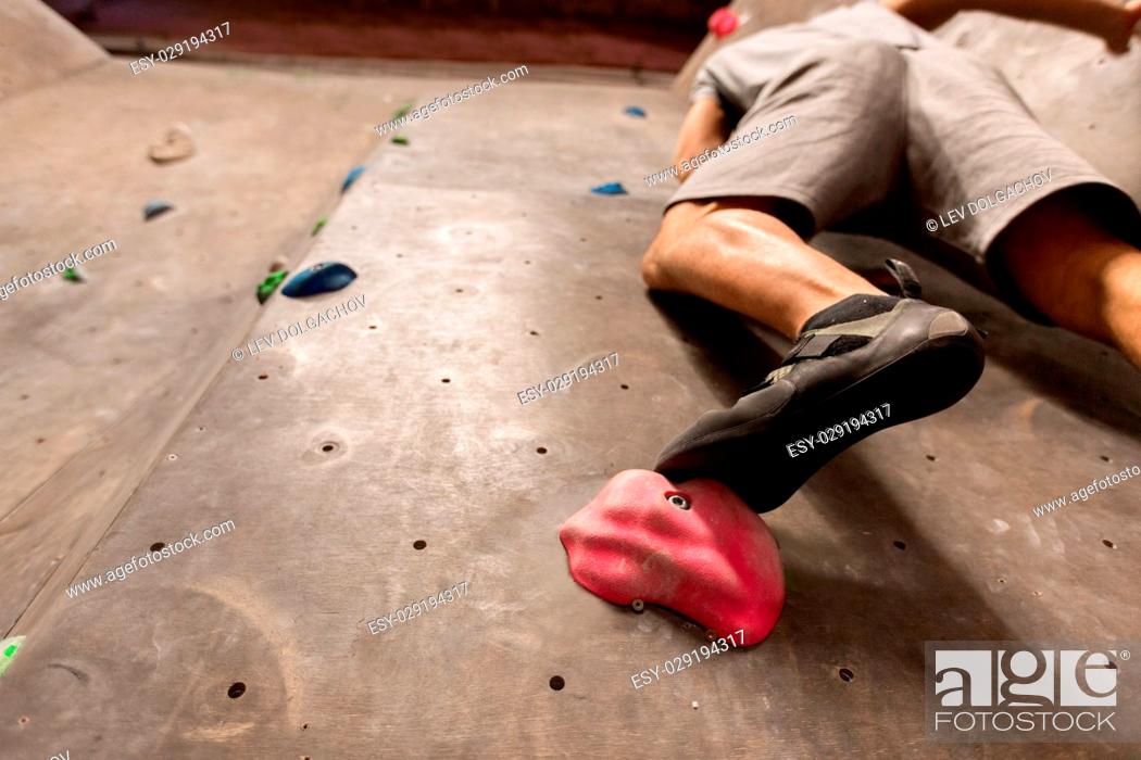 Stock Photo: fitness, extreme sport, bouldering, people and healthy lifestyle concept - foot of young man exercising at indoor climbing gym.