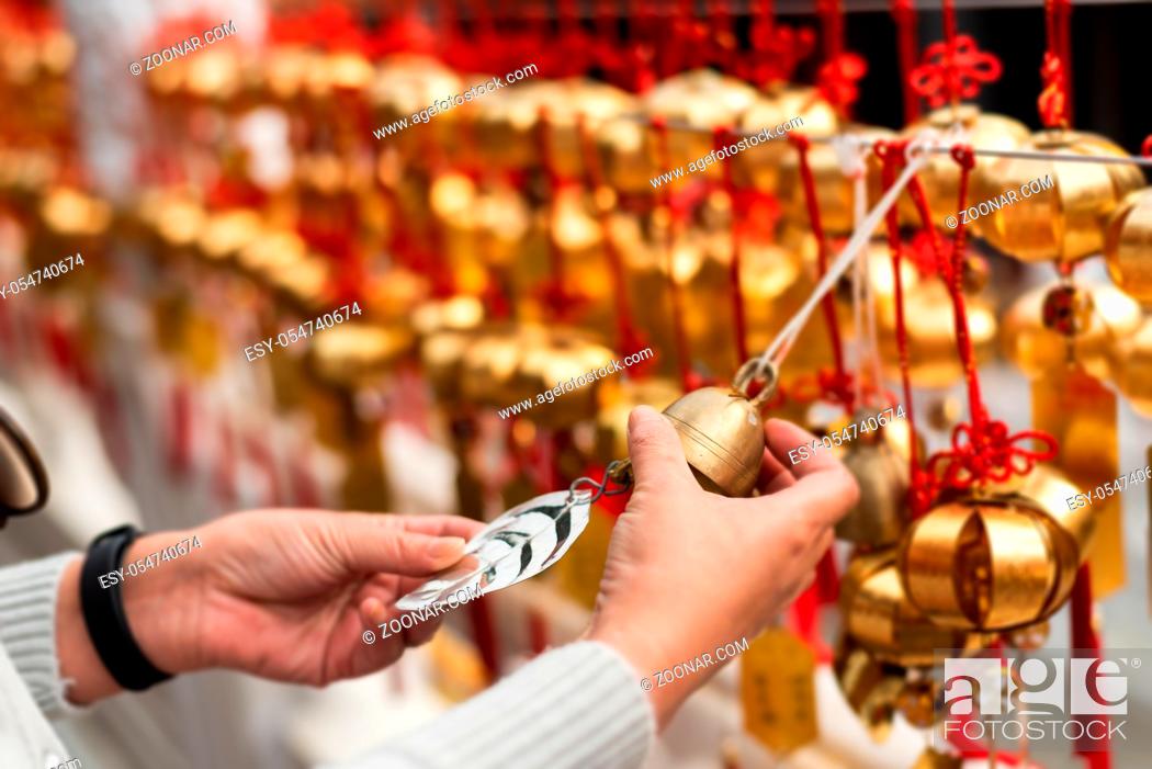Stock Photo: traveling woman look at the golden bells of wish wall on Wenwu Temple, Taiwan.