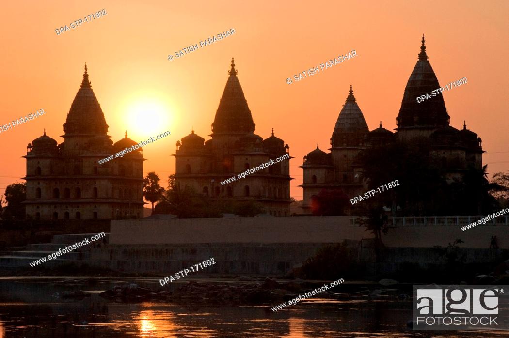 Stock Photo: Sunset with cenotaphs at bank of river Betwa , Orchha , Tikamgarh , Madhya Pradesh , India.