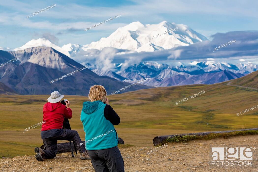 Photo de stock: Two tourists photograph Mt. McKinley and Thorofare Pass from Stony Dome in Denali National Park, Interior Alaska, Summer, USA.