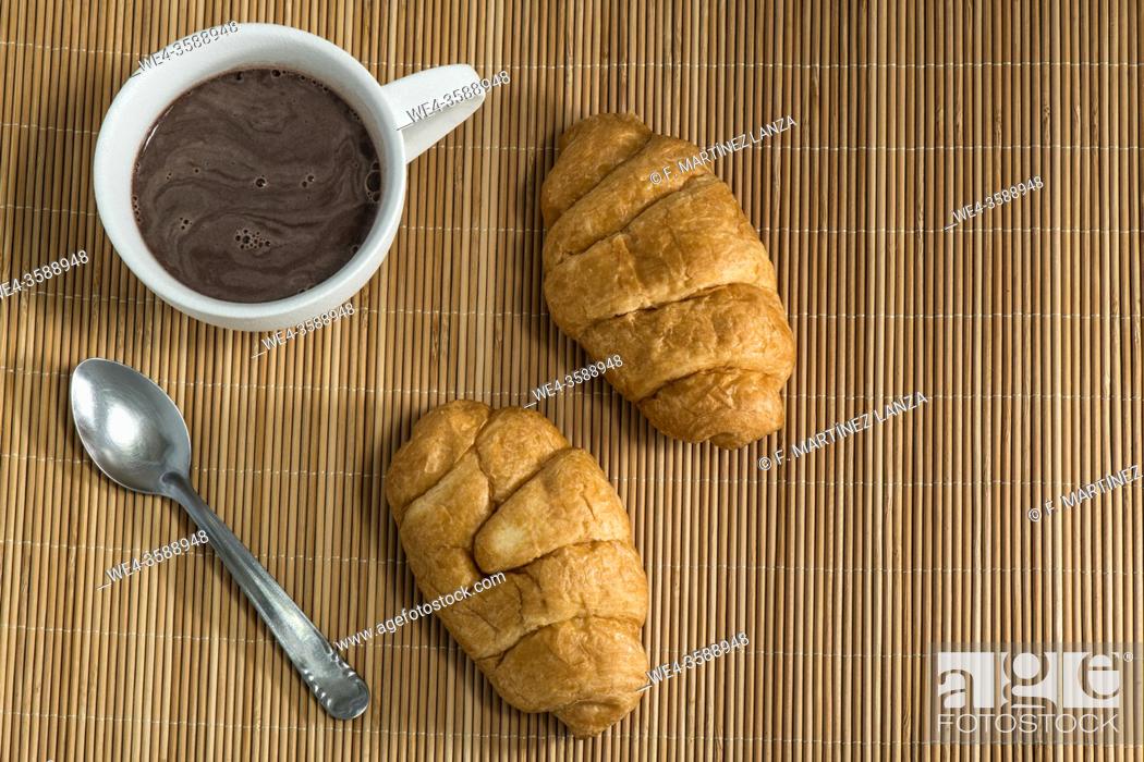 Stock Photo: Cup of chocolate and croissant on a mat.