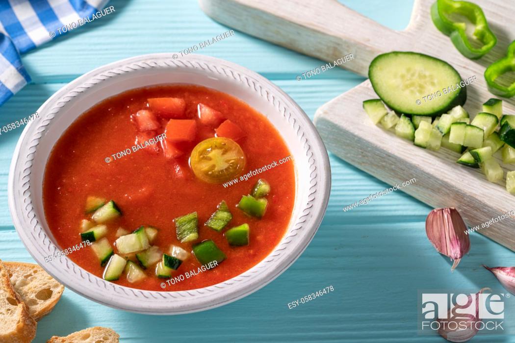 Stock Photo: Gazpacho Andaluz is an Andalusian tomato cold soup from Spain with cucumber, garlic, pepper on light blue background.