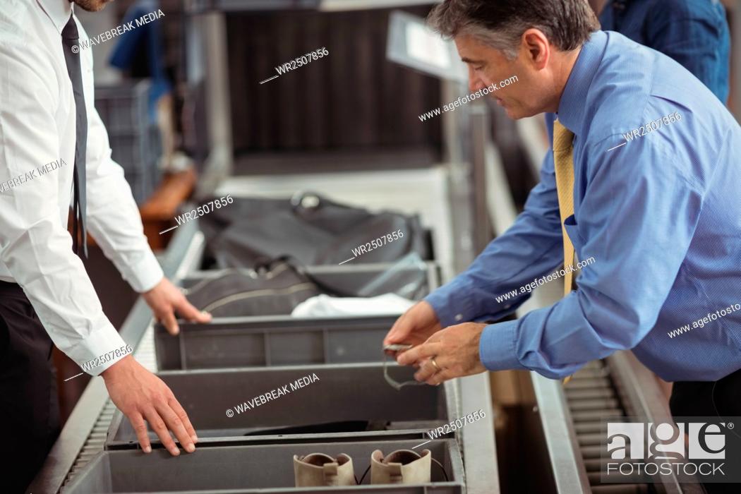 Stock Photo: Man putting watch into tray for security check.