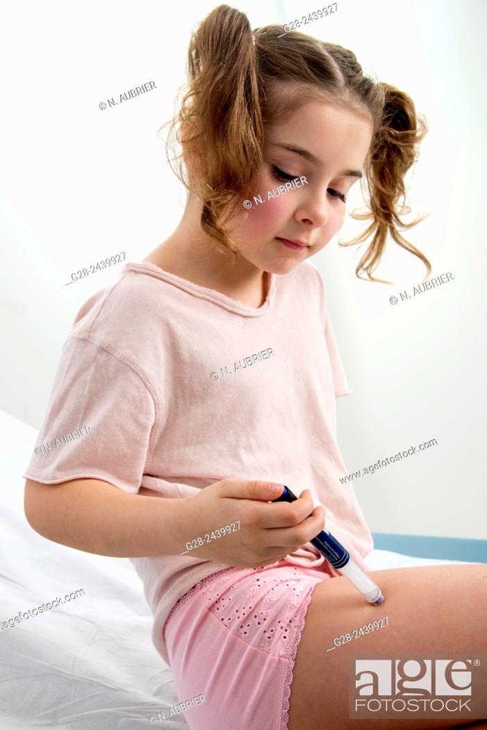 Stock Photo: Little girl with bunches suffering from diabetes injecting herself insulin.