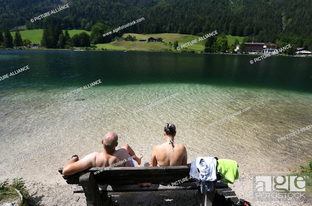 Imagen: 13 August 2021, Bavaria, Hintersee: A couple enjoys the cool Hintersee with their feet in the water. The mountain lake lies at over 789 above sea level.