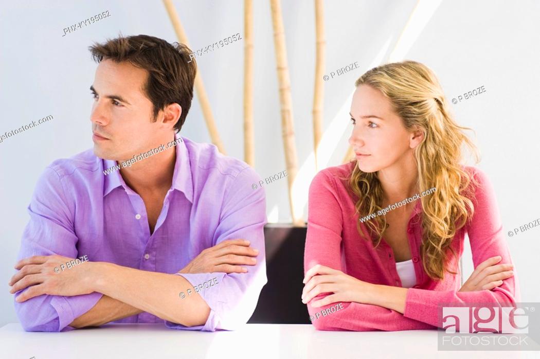 Stock Photo: Couple sitting side by side and ignoring each other.