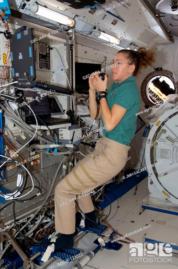 Stock Photo: Astronaut Sandra Magnus, Expedition 18 flight engineer, uses a communication system while performing a function test of the Japanese Remote Manipulator System.