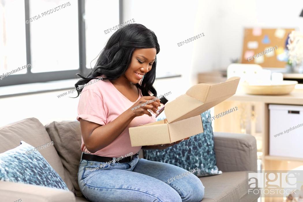 Stock Photo: african american woman opening parcel box at home.