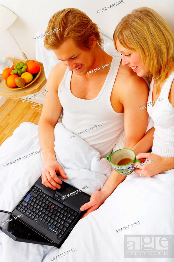 Young couple browsing the internet from their bed This is As