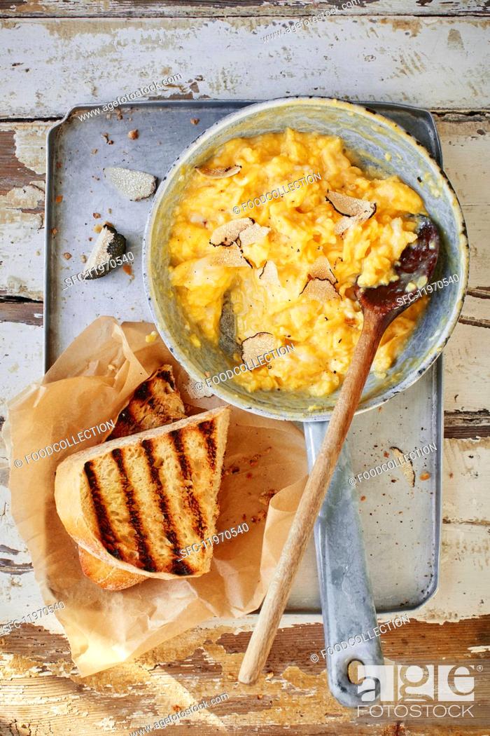Stock Photo: Scrambled egg with truffles in a pan with toast.