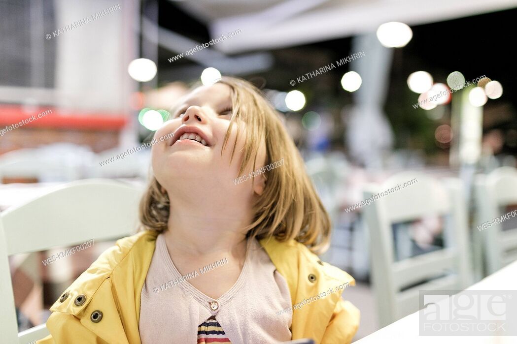 Stock Photo: Little girl sitting in a restaurant watching something.