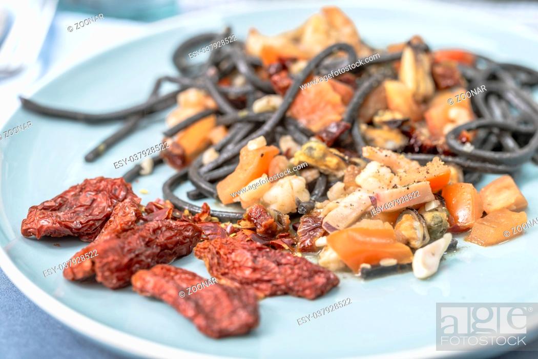 Photo de stock: Spaghetti with squid ink with seafood and tomatoes.