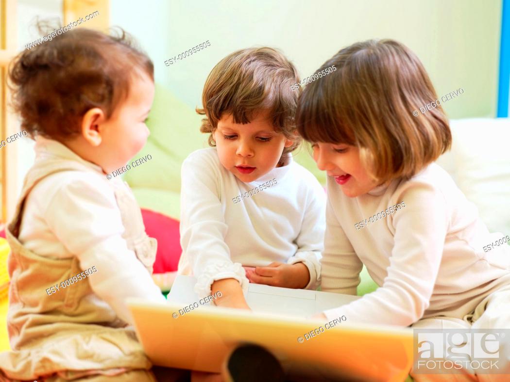 Stock Photo: three little girls and female teacher in kindergarten.