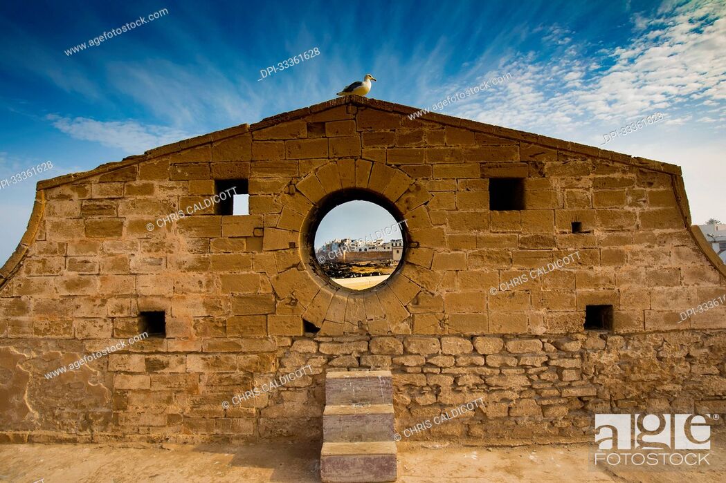 Stock Photo: Circular window in the wall of the Sqala du Port walkway to the Essaouira Citadel; Essaouira, Morocco.