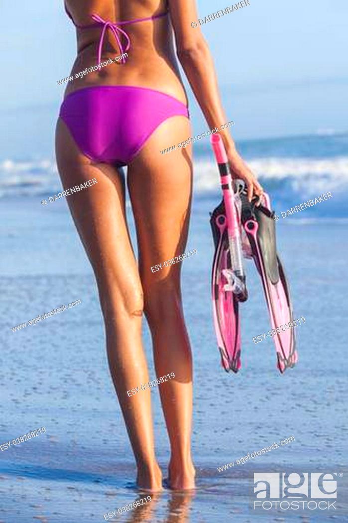 Imagen: A sexy young woman or girl wearing a bikini on a deserted tropical beach with diving equipment, snorkel, mask & flippers or fins.