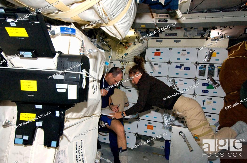 Stock Photo: Astronauts Sandra Magnus, Expedition 18 flight engineer, and Greg Chamitoff, STS-126 mission specialist, work on the middeck of Space Shuttle Endeavour while.