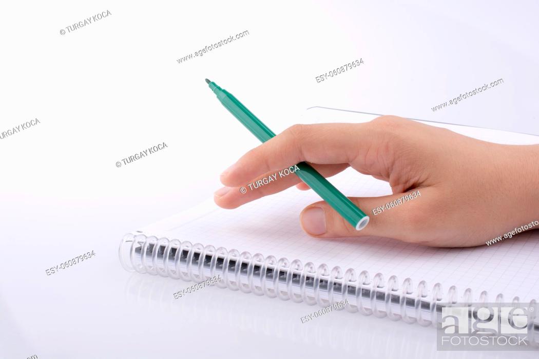 Photo de stock: Hand writing on a Notebook with a pen on a white background.