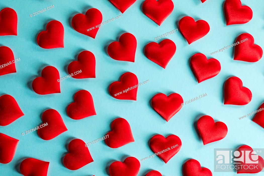Stock Photo: Valentine's day many red silk hearts on blue paper background, love concept.