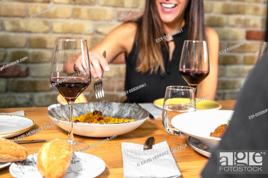 Stock Photo: Unrecognizable Group of friends eating together and drinking wine in a restaurant. High quality photo.