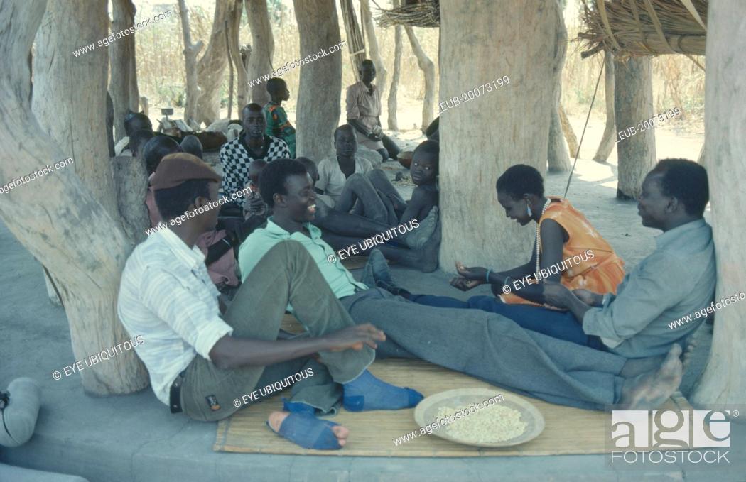 Stock Photo: Dinka people gathered for story telling in village meeting house.