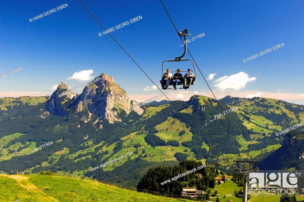 Stock Photo: Tourists on ski lifts at mountainous landscape, Switzerland.
