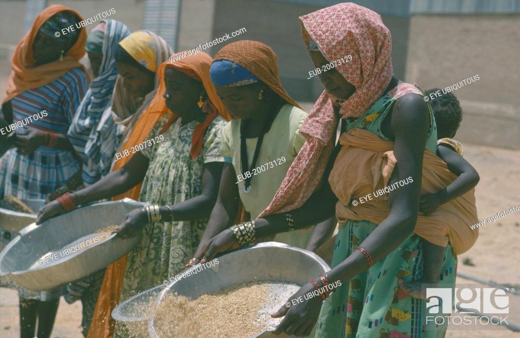 Stock Photo: Nigerian women winnowing rice.
