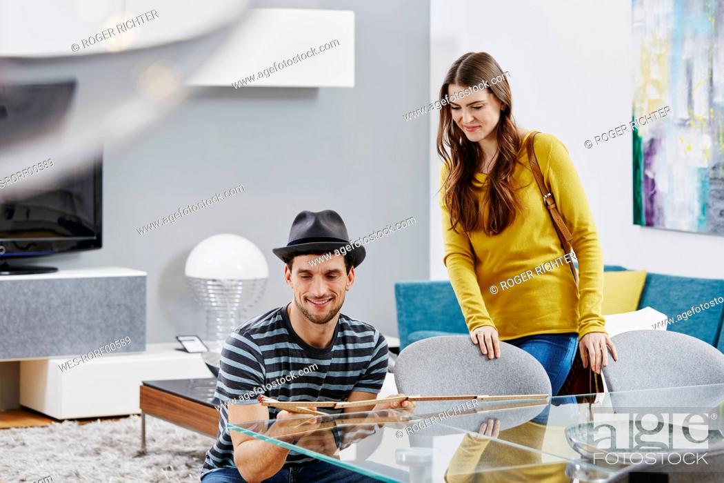 Photo de stock: Couple in furniture store measuring dining table with pocket rule.