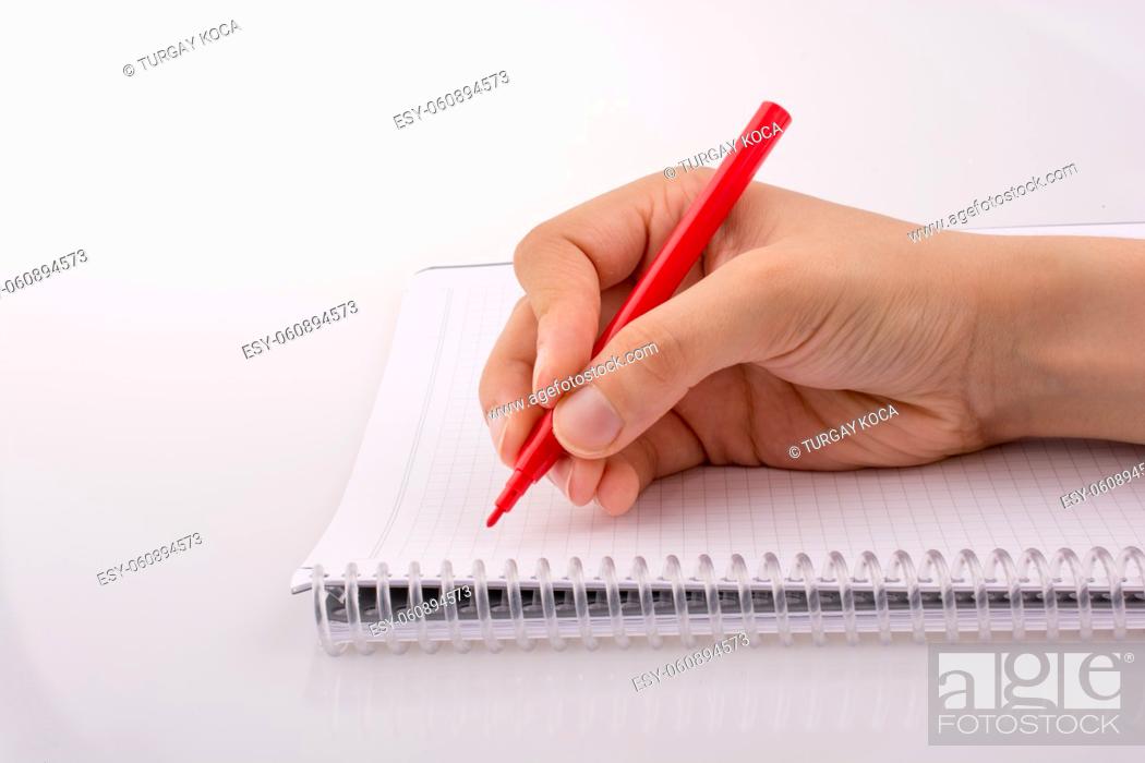 Photo de stock: Hand writing on a Notebook with a pen on a white background.