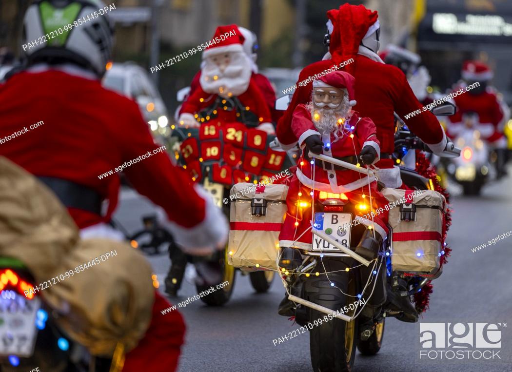 Stock Photo: 10 December 2022, Berlin: Participants in the ""Santa Claus on Road"" campaign ride through the city on their Christmas-decorated machines.