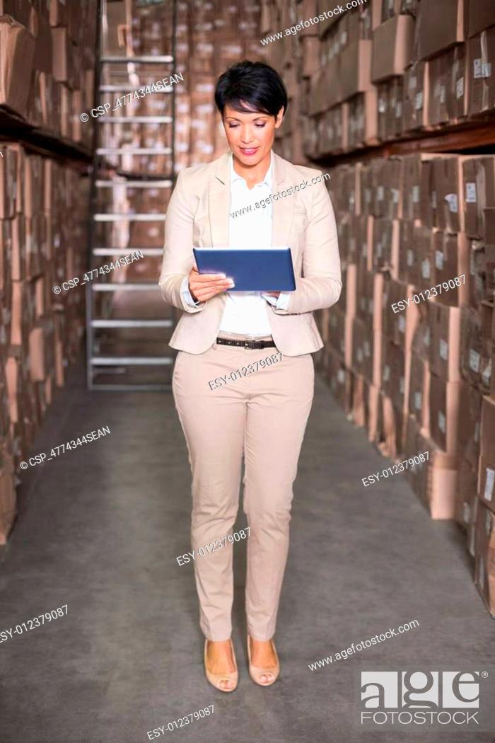 Stock Photo: Pretty warehouse manager using tablet pc.
