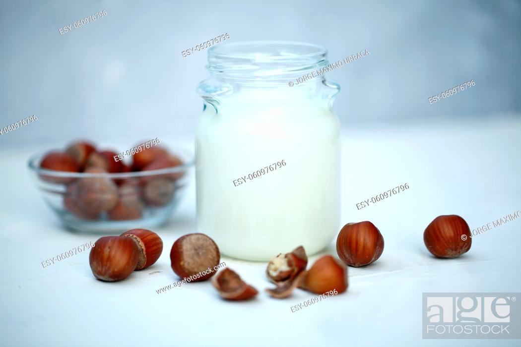 Stock Photo: Hazelnut milk on white wooden board.