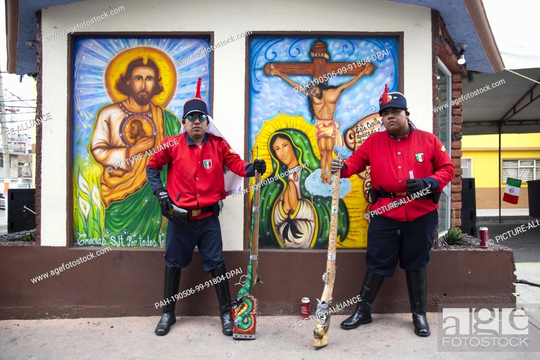 Stock Photo: 05 May 2019, Mexico, Mexiko-Stadt: Two men in uniforms stand in front of a mural as part of a reenactment of the Battle of Puebla.